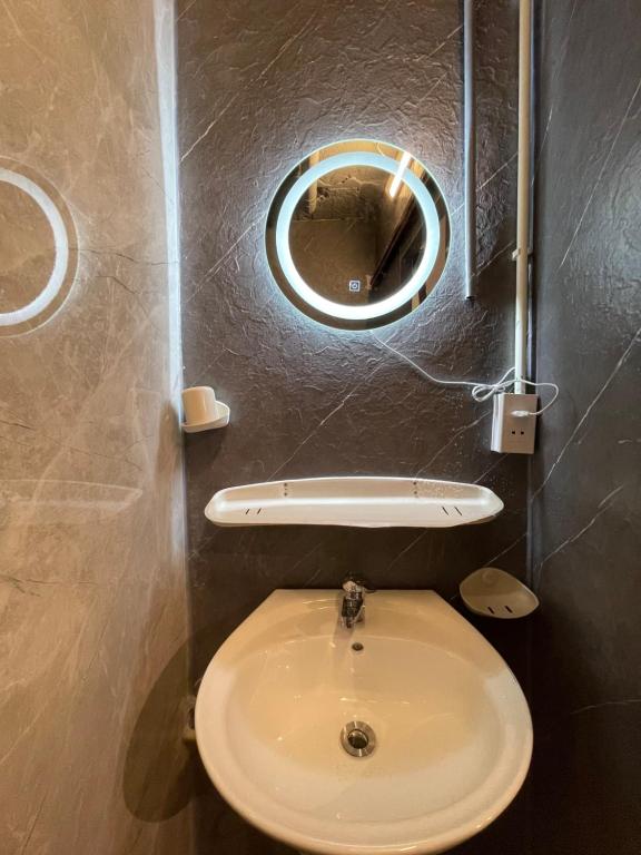 a bathroom with a toilet with a round mirror at Ubuntu Central Stay 57 Hang Be in Hanoi