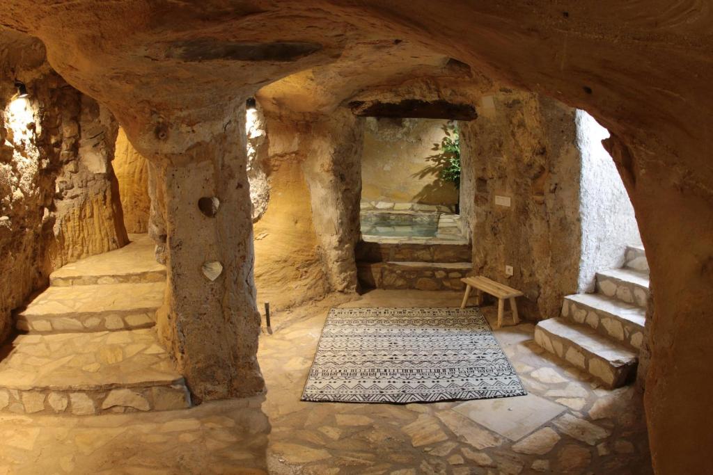 a stone building with a hallway with stairs and a rug at Piedra y Luz in Buendía