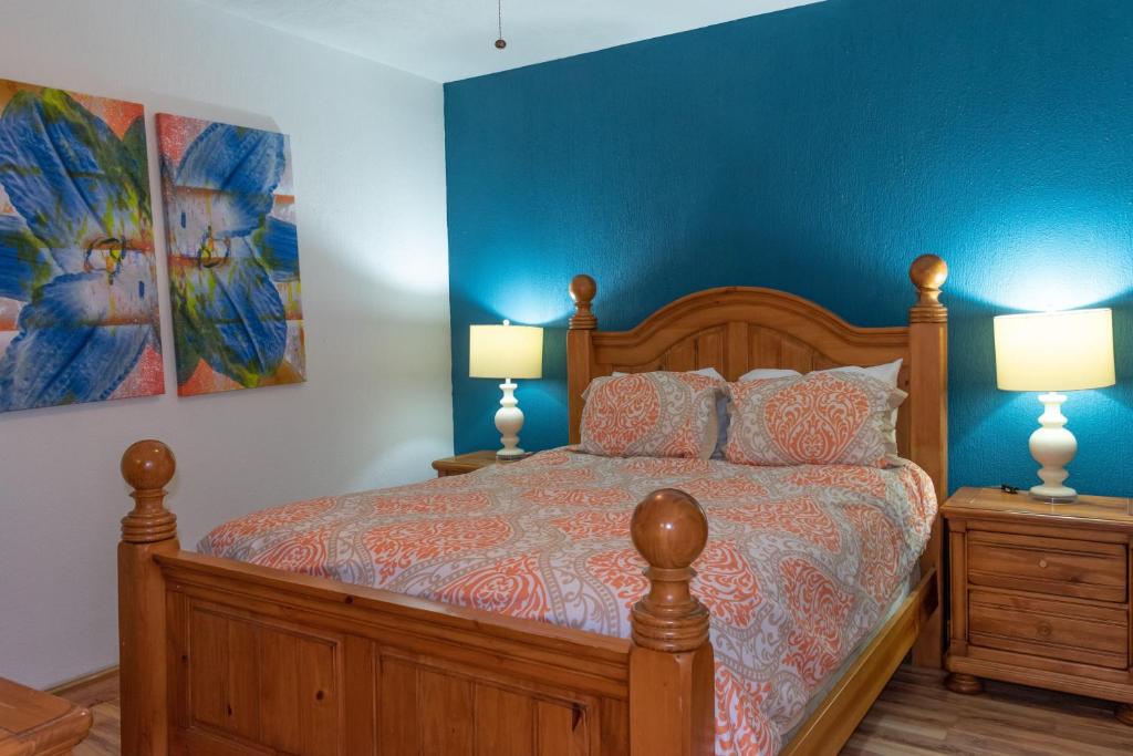 een slaapkamer met een bed met blauwe muren en 2 lampen bij Sonoran Spa W404 in Campo del Medio
