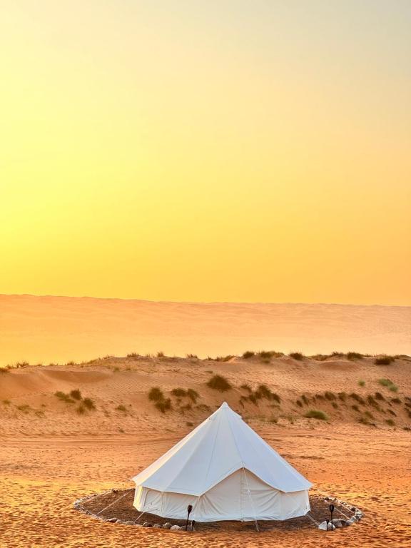BadīyahStars Dunce Camp的沙漠中的一个白色帐篷