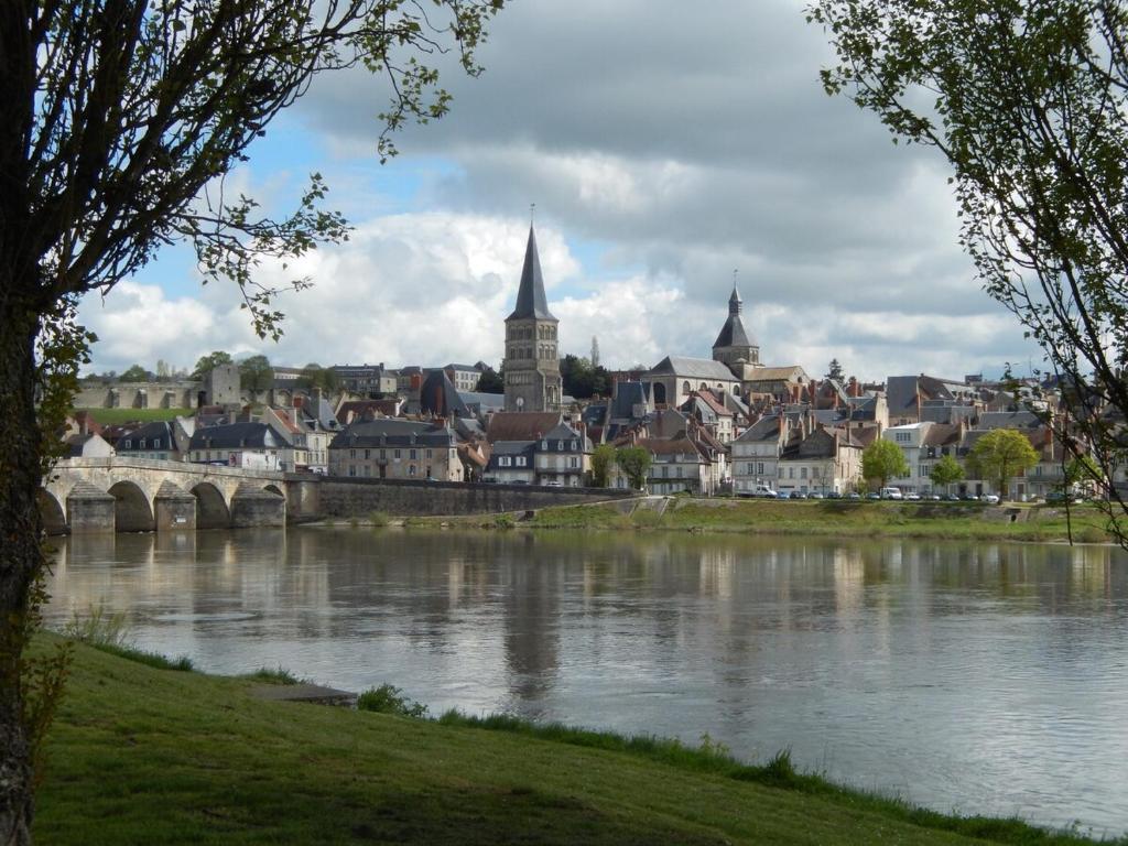 a city with a river and a bridge and buildings at Logement indépendant dans cité médiévale in La Charité-sur-Loire