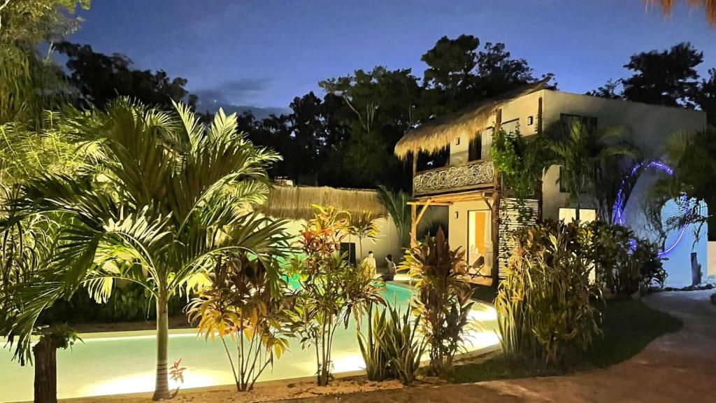 una casa con palmeras delante en Villa AHAL,, en Chemuyil