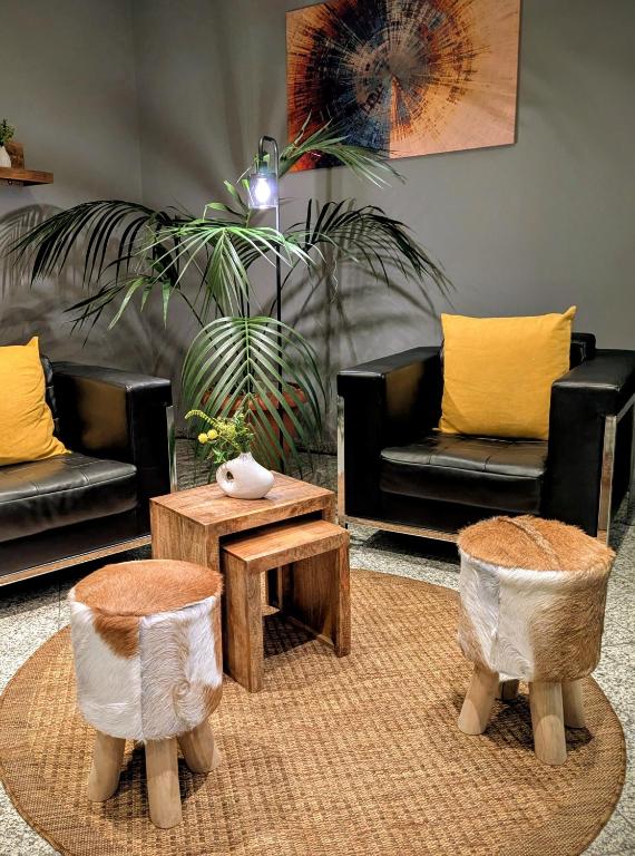 a living room with two couches and a coffee table at Hotel Herian in Parsdorf
