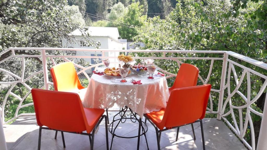 a table on a balcony with chairs and a table with food at Green Garden Dilijan in Dilijan
