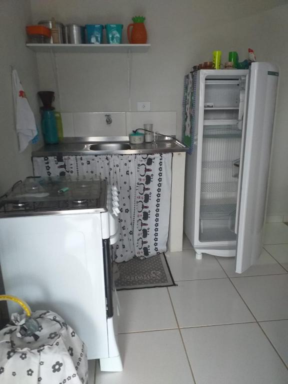 a small kitchen with a refrigerator and a sink at Kitnet manacá in Paraty