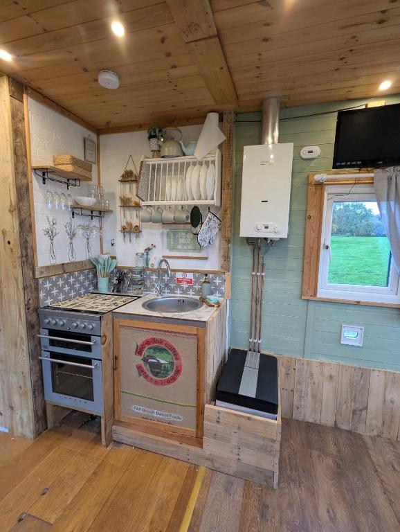 a kitchen with a sink and a stove in a room at The Horsebox at Wits End in Hartford