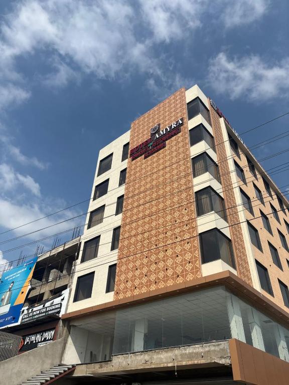 a building with a clock on the side of it at Hotel Amyra in Kota