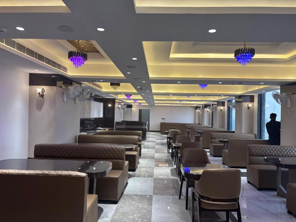 a dining room with chairs and tables and lights at Hotel Amyra in Kota