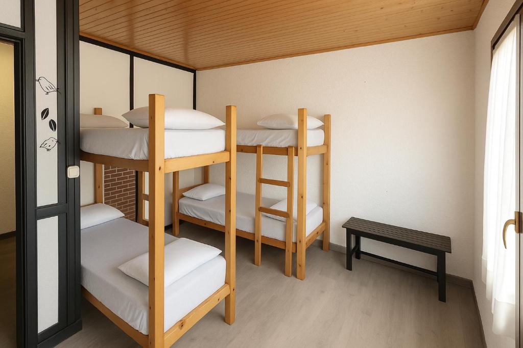 una habitación con tres literas en una habitación en Albergue Tritón - Villanúa, en Villanúa