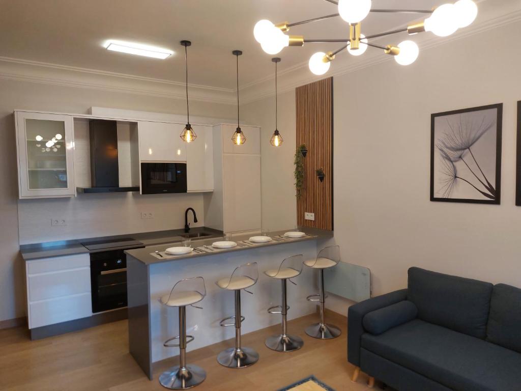 eine Küche mit Couch und Kücheninsel mit Hockern in der Unterkunft Apartamento Puerta de San Fernando in Lugo