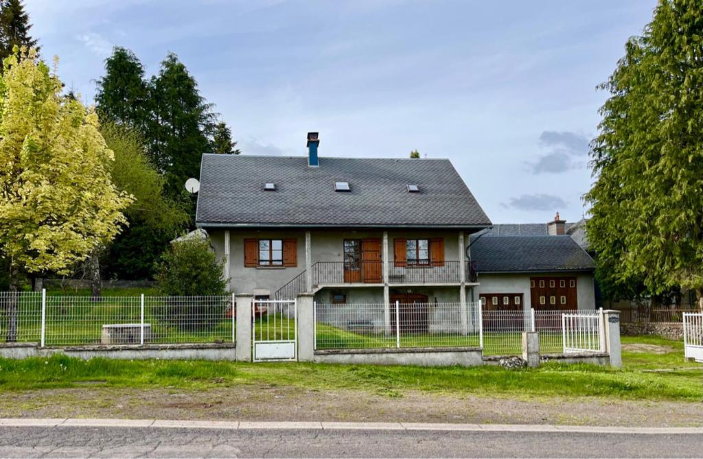 an old house with a fence in front of it at Gîte 6 personnes Chez Gaby in Montgreleix