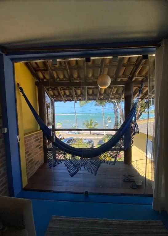 a hammock on a porch with a view of the ocean at Casa Sol Nascente in Itacaré