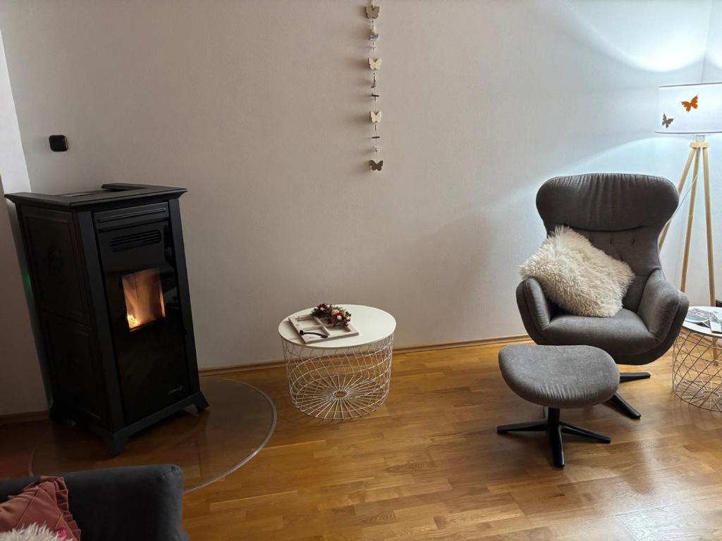 a living room with a chair and a fireplace at Fewo EifelLenz in Hellenthal