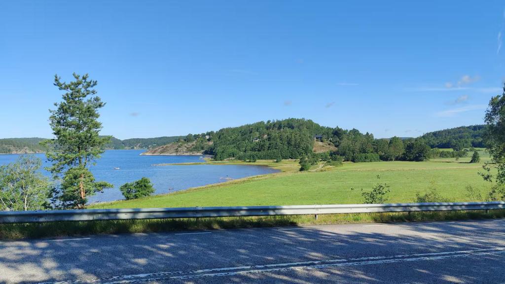 a road with a view of a river and a field at Skutviken in Henån