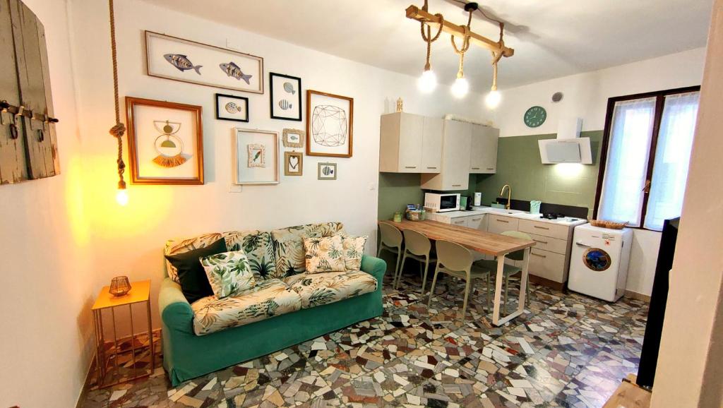 a living room with a couch and a table and a kitchen at Coramino in Chioggia