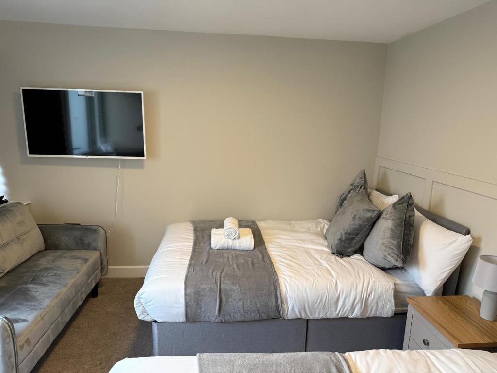 a room with a bed and a couch and a flat screen tv at Modern Studio London Near Hospital in Thornton Heath