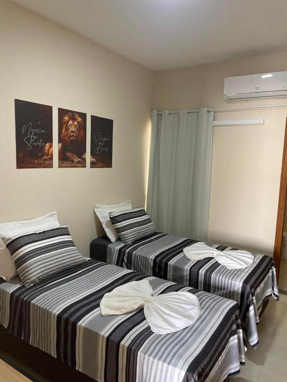 two beds sitting next to each other in a room at Apartamento solteiro sinop 9 in Sinop