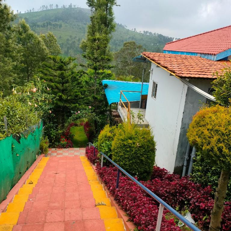 a walkway in a garden with flowers and a house at Wild Nest Kotagiri in Kotagiri