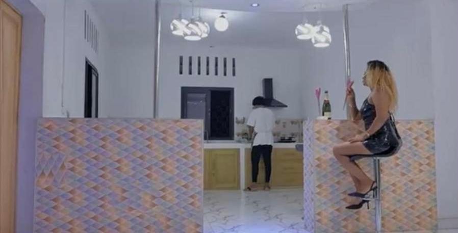 a woman sitting on a chair in a kitchen at Le megève in Antalaha