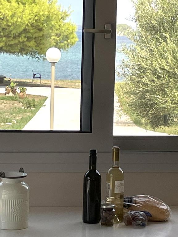 two bottles of wine sitting on a counter in front of a window at BEACH WHTE VILLAs one bedroom in Minia