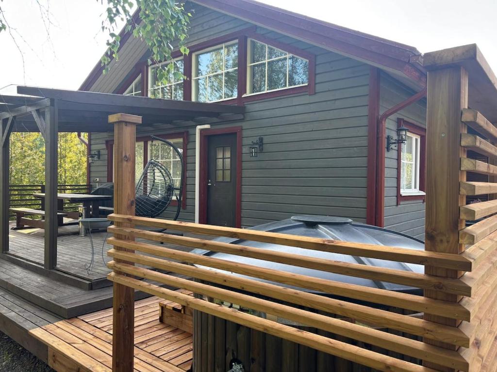 una casa con terrazza in legno con pergolato di Luksushuvila louhosjärven rannalla a Isokyrö