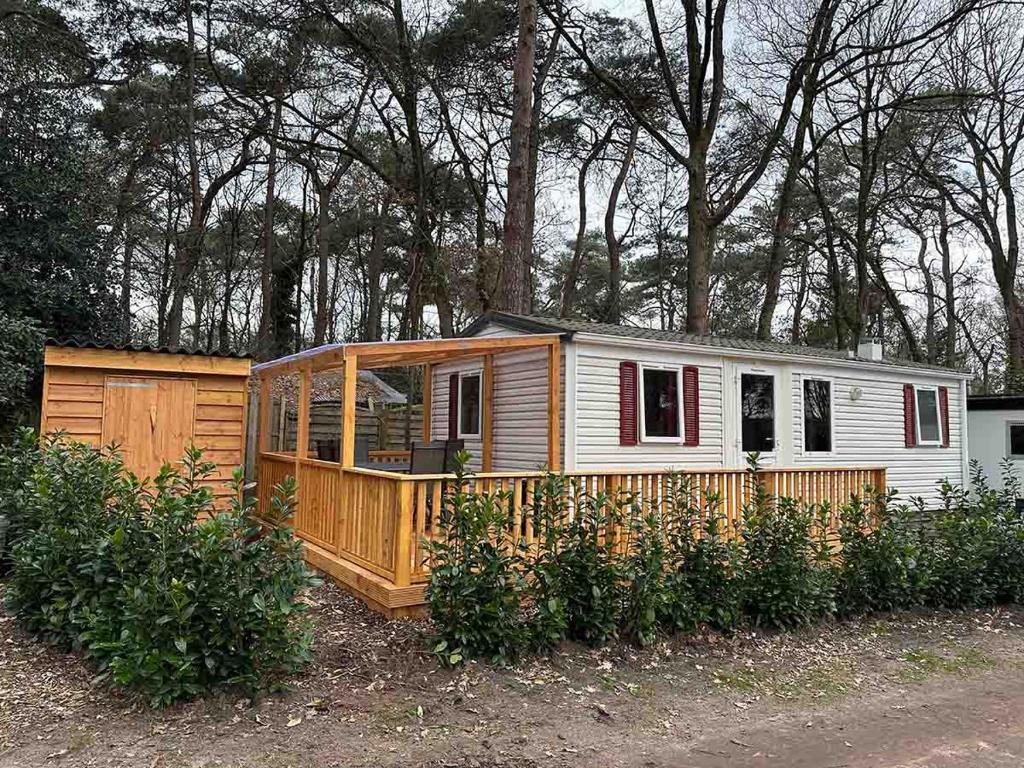 a small wooden house in a yard with trees at De Berk in Zuidwolde