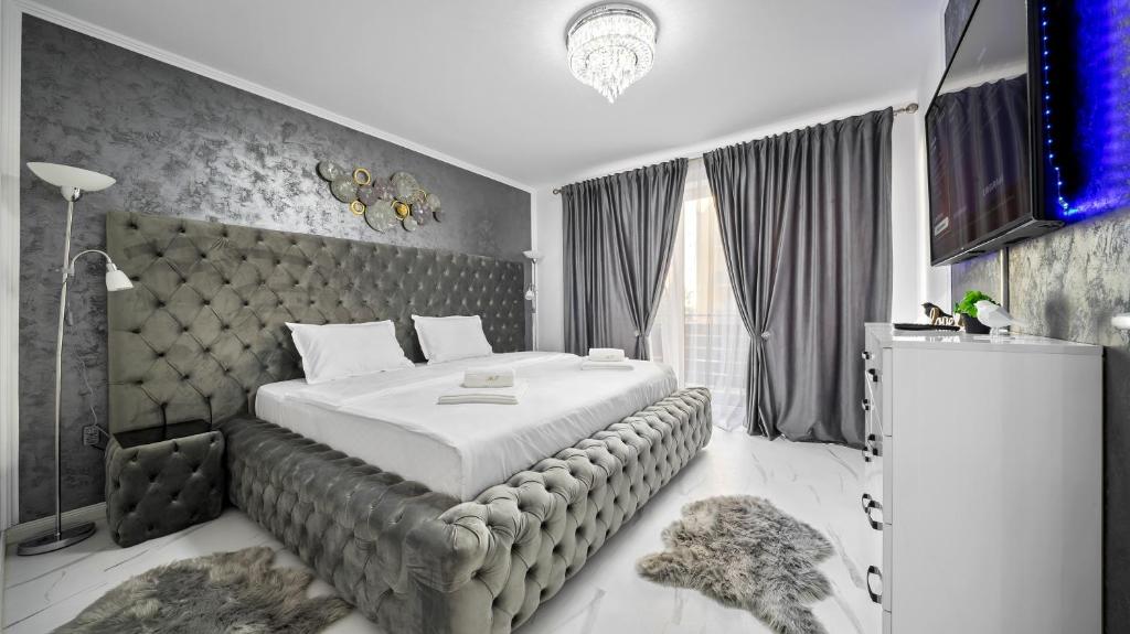 a bedroom with a large bed and a large window at RT Luxury Royal Residence in Braşov