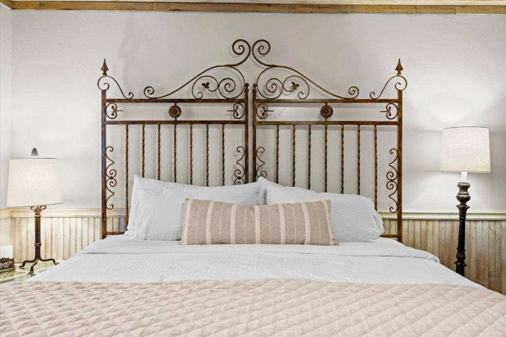 ein Schlafzimmer mit einem großen Bett mit einem hölzernen Kopfteil in der Unterkunft Adobe Village Studio Suite- Tumbleweed in Oak Creek