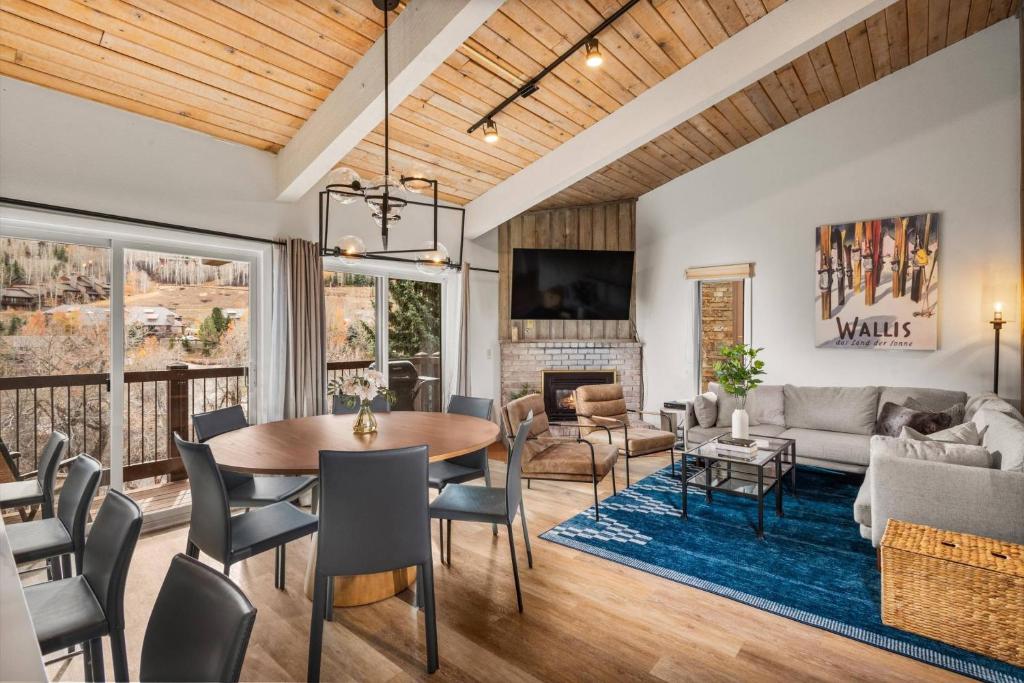 a living room with a table and chairs and a fireplace at Woodbridge 29E in Snowmass Village