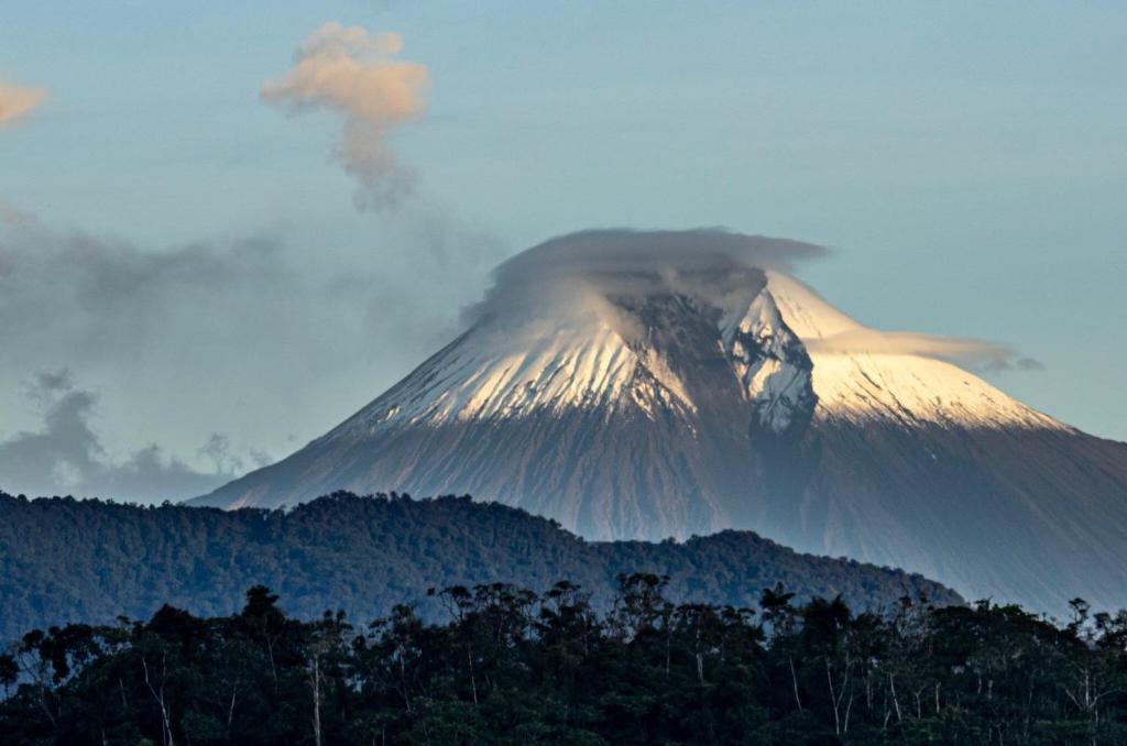un volcán en erupción con una nube en la cima en Centro Macas, en Macas