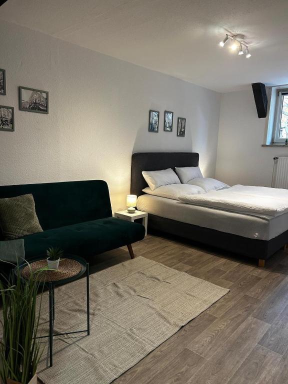 a living room with a bed and a couch at Apartment London in Bergen an der Dumme