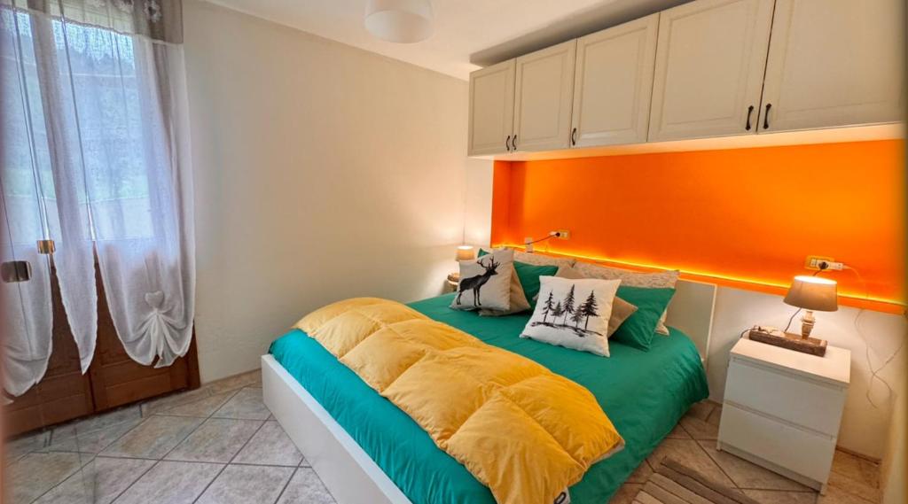 a bedroom with a bed with an orange headboard at App G&G in Sagron Mis