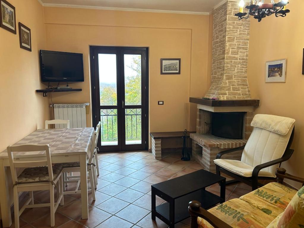 a living room with a table and a fireplace at La Piccola Stella in Castel del Giudice