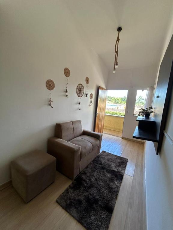 ein Wohnzimmer mit einem braunen Sofa und einem Teppich in der Unterkunft Do sol in Porto Seguro