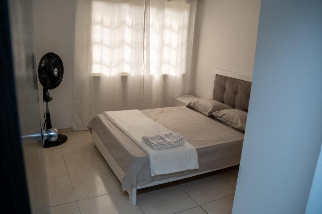 カリにあるHermosa casa en caliのベッドルーム1室(ベッド1台、窓、ファン付)が備わります。