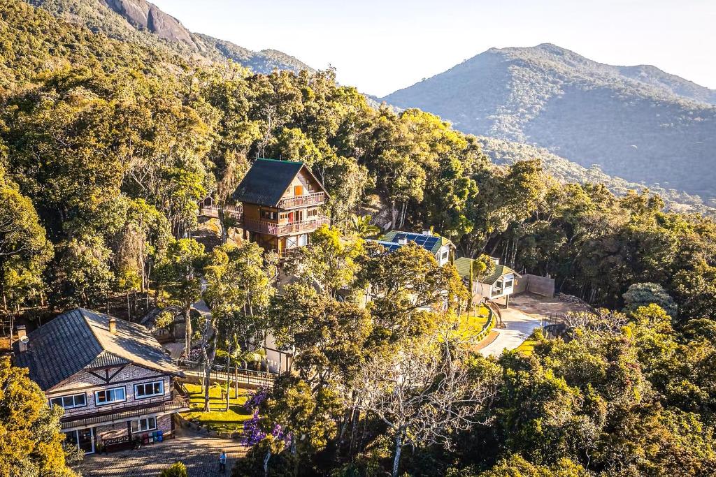 a house on the side of a mountain with trees at VELINN Pousada Pedras e Sonhos in Monte Verde