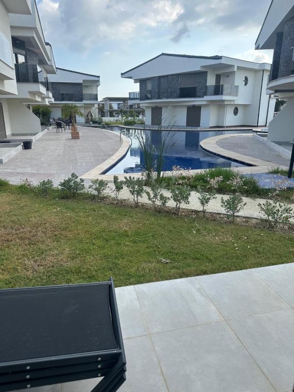 a bench sitting in front of a swimming pool at Charmante, moderne Wohnung 10 Minuten Fußweg zum Strand! in Side