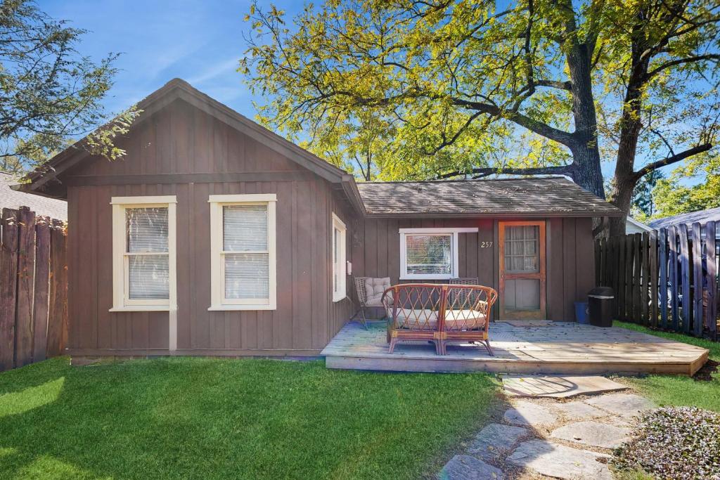 a brown shed with a bench in the yard at Main Street Wood Cottage in Brevard