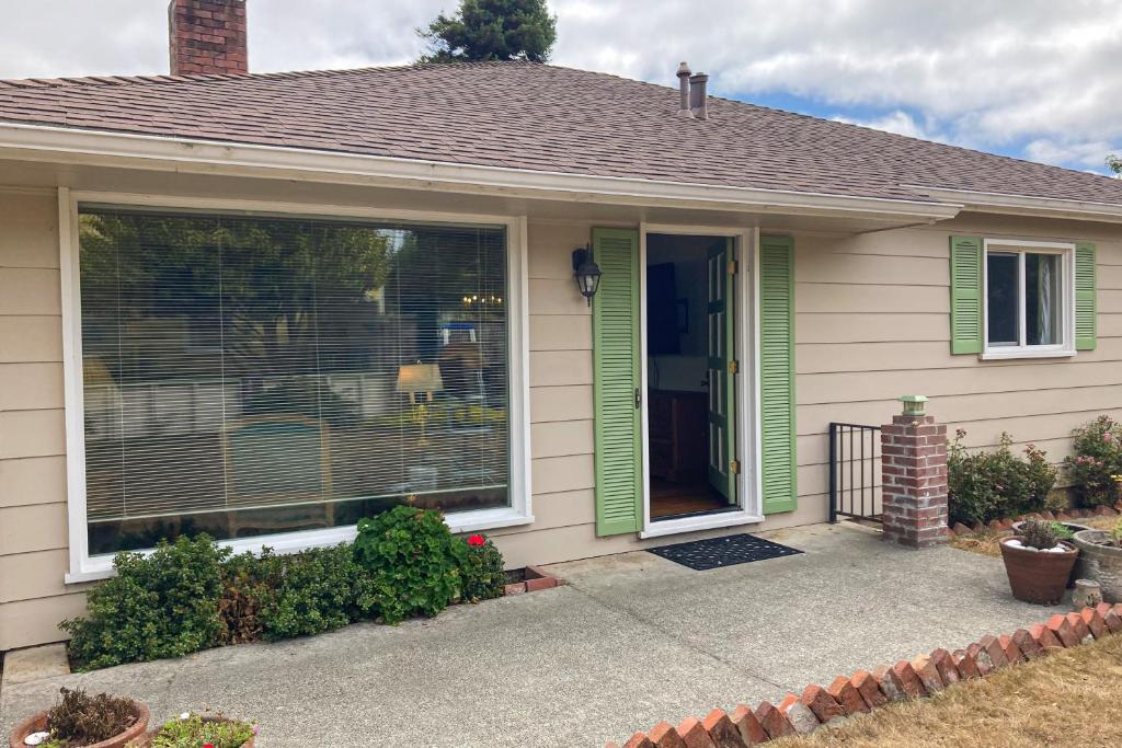 a house with green shutters and a front door at West End Wanderlust in Eureka