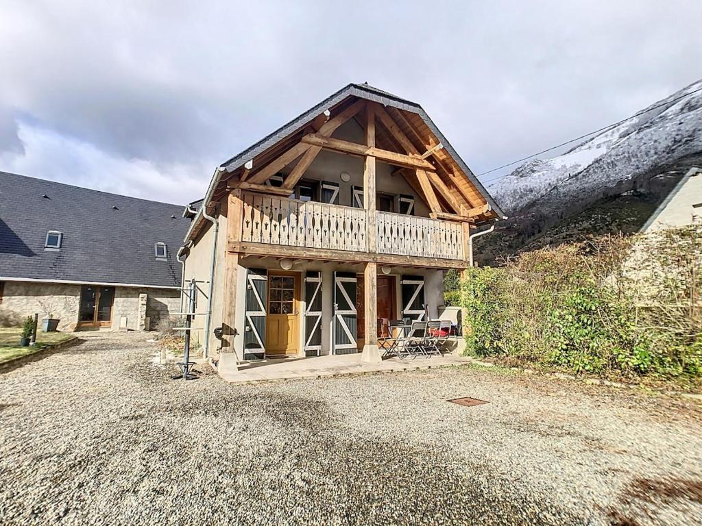 een houten huis met een balkon erboven bij Cocon cosy au cœur des Pyrénées in Campan