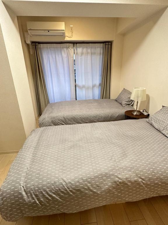 zwei Betten in einem Zimmer mit Fenster in der Unterkunft # 3 Katsu House日本桥地铁站6分 in Wada