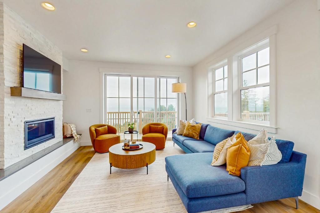 a living room with a blue couch and a fireplace at Pacific Perch in Depoe Bay