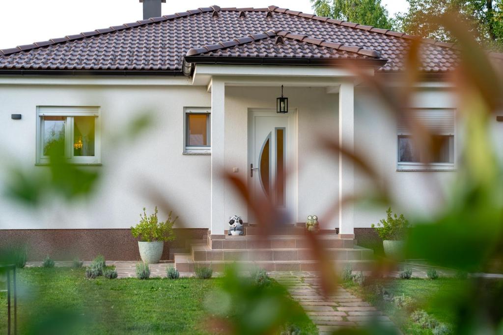 een wit huis met een voordeur bij House4Seasons in Lič