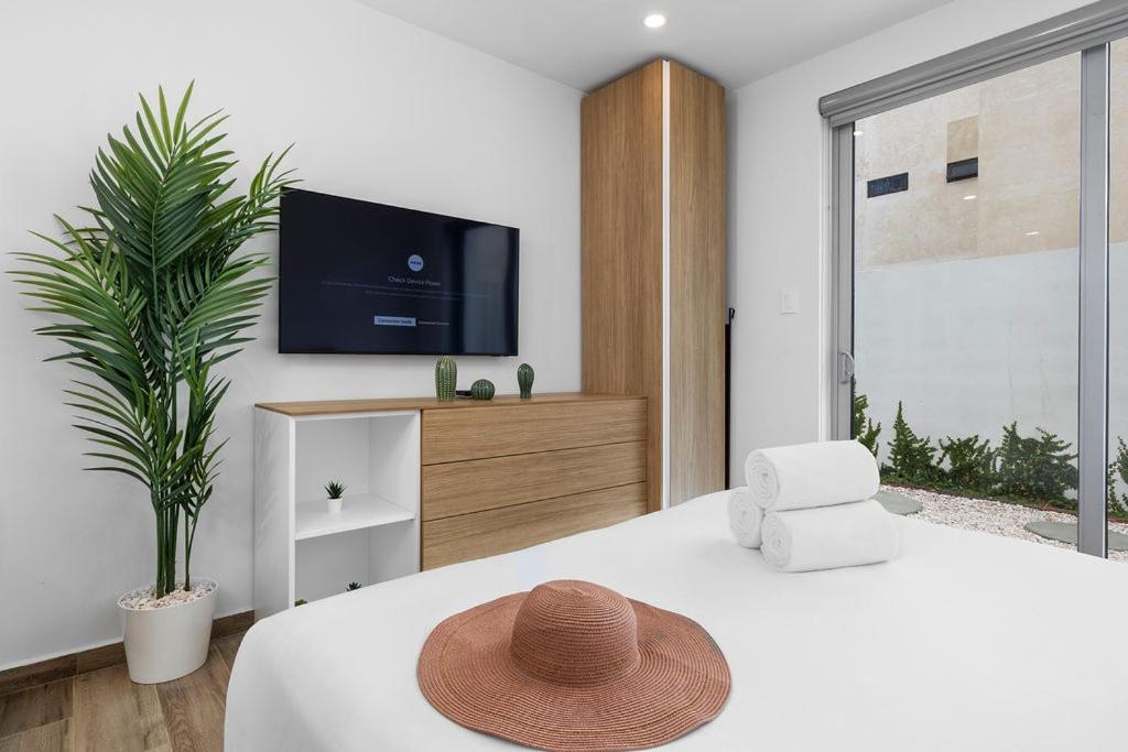 a bedroom with a bed with a hat on it at BRAND NEW Studio w/Pool, GYM, Rooftop @ Palm Beach in Palm-Eagle Beach