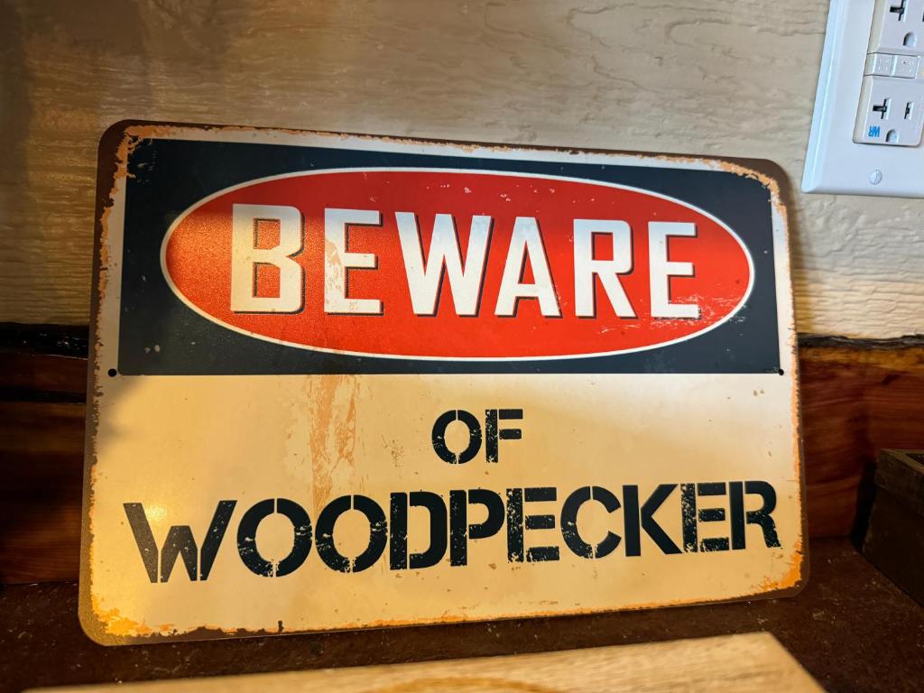 a beware of woodspeaker sign on a wall at "Morning Wood" Luxury Treehouse Retreat Near Dollywood & Pigeon Forge in Sevierville