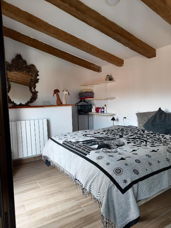 a bedroom with a bed in a room with wooden floors at La casa del patio in Ágreda