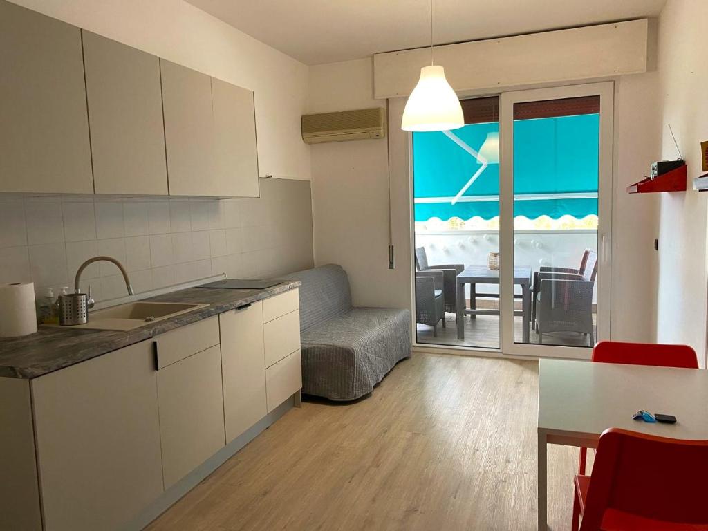 a kitchen with a view of the ocean and a dining room at Studio Lido 10 in Lido delle Nazioni