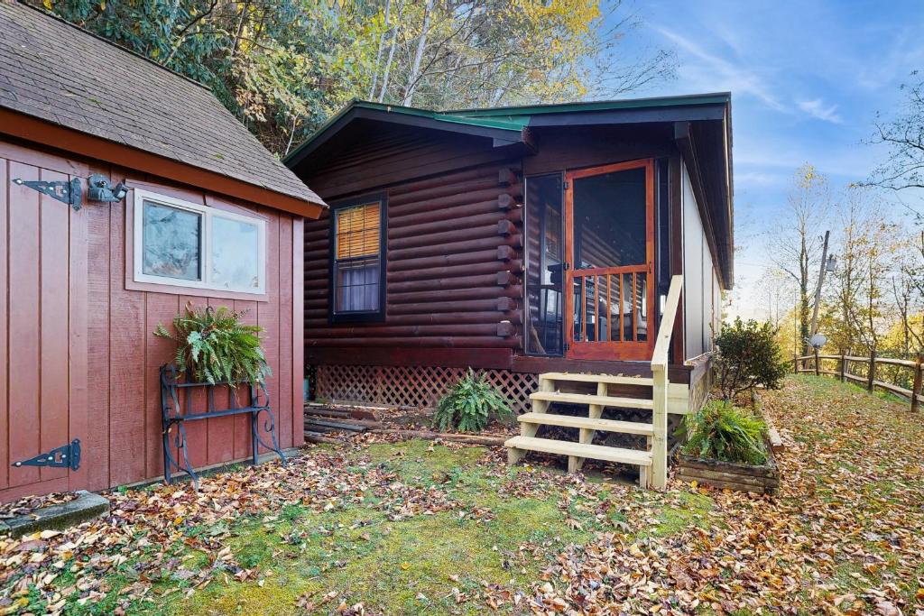 a log cabin with a staircase next to a house at Papa's Cabin in Wilmot