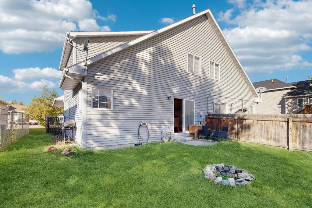 a white house with a fence and a yard at The Anglers Retreat - Unit A in Belgrade