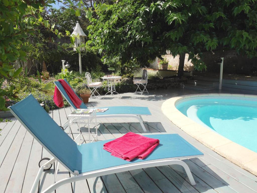 une terrasse avec des chaises et une piscine dans l'établissement L'Arbre D'Ange, à Montmorillon